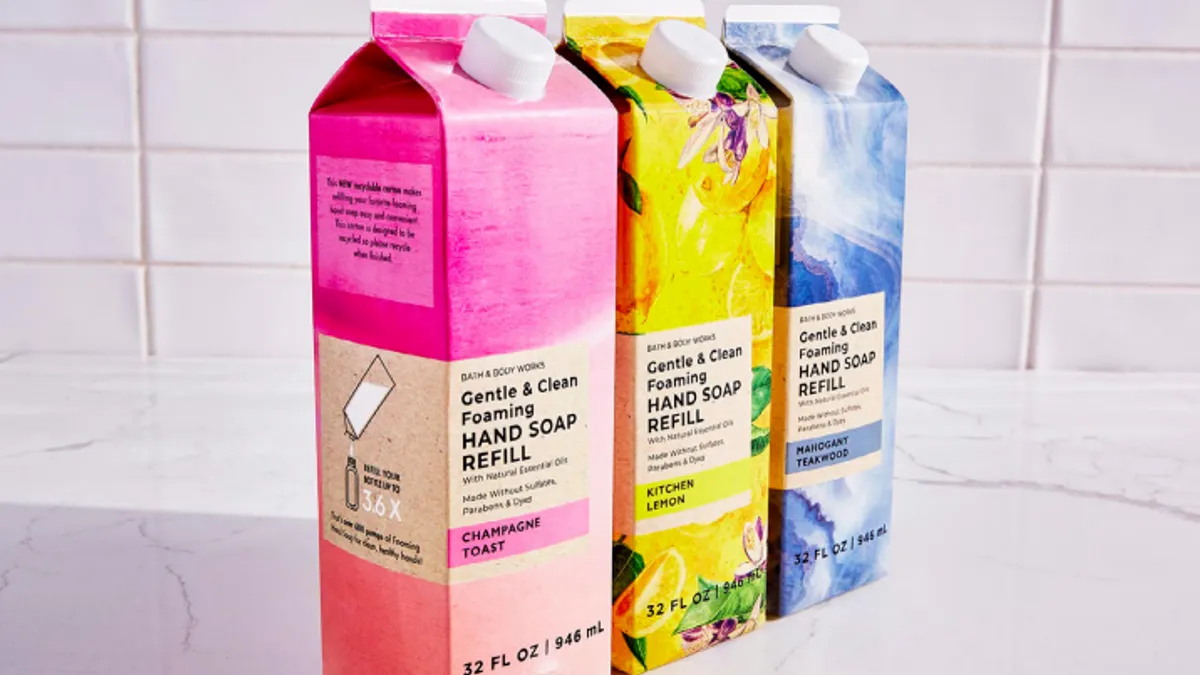 Three brightly colored quart-sized cartons with messaging describing Bath and Body Works' soap refill products.