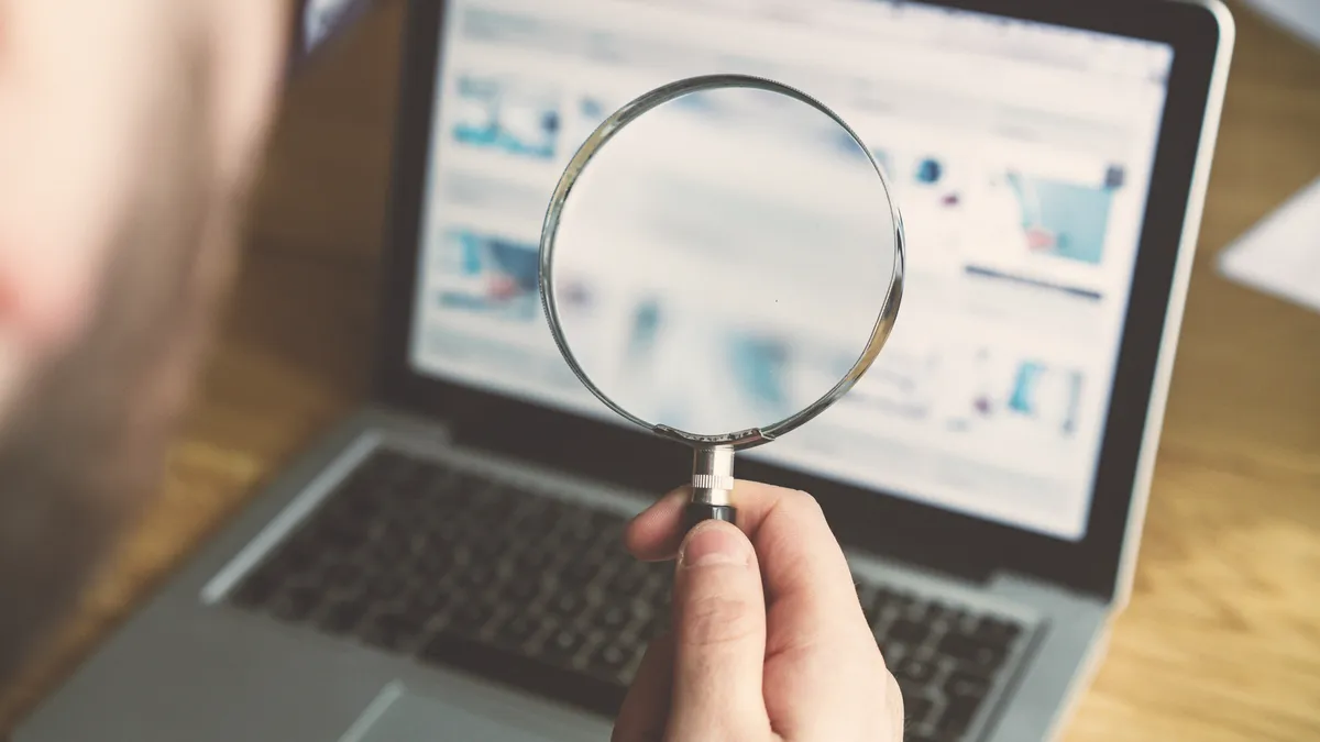 A magnifying glass held up to a computer