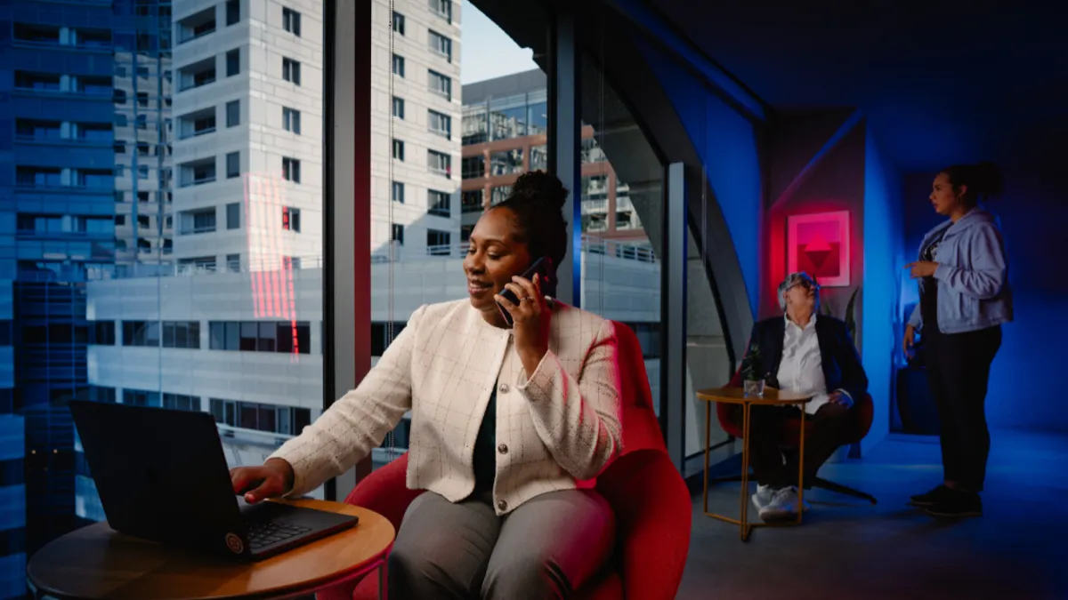 Woman on phone, working on computer