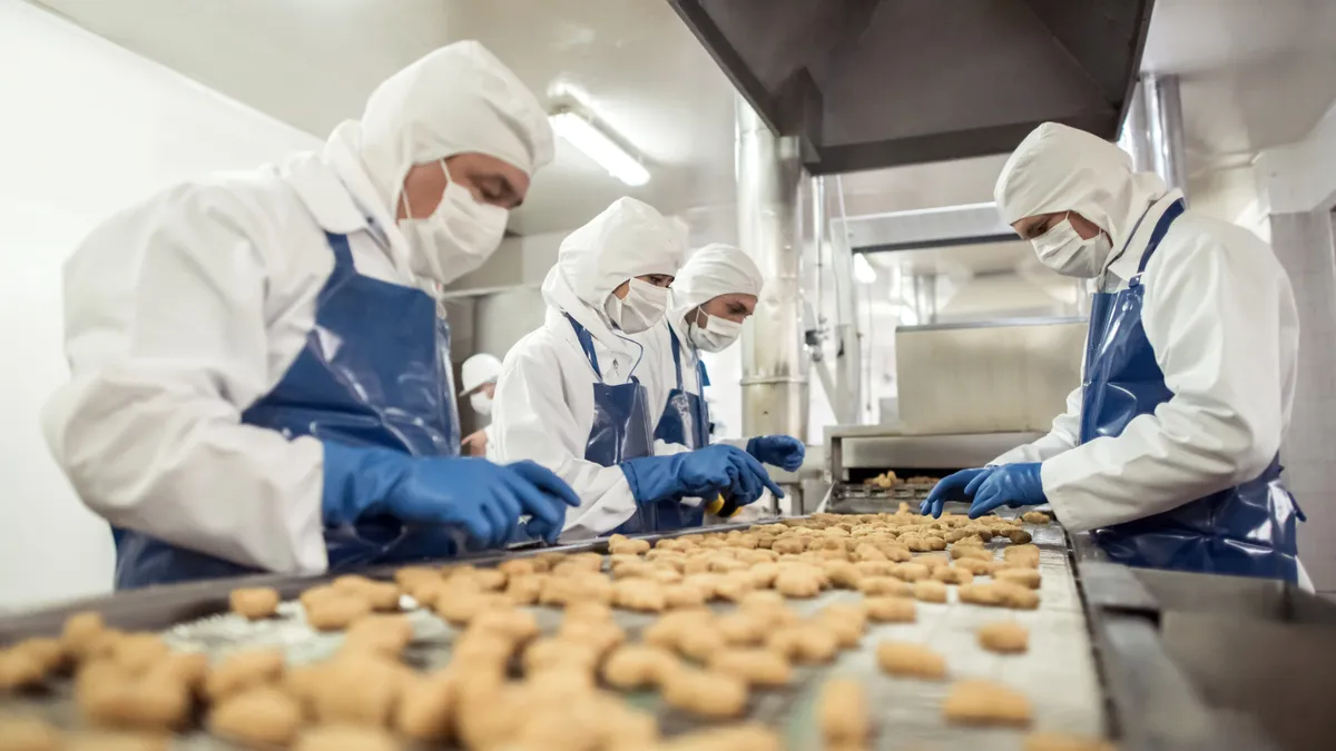 Group of people working at a food factory doing quality control on the production line