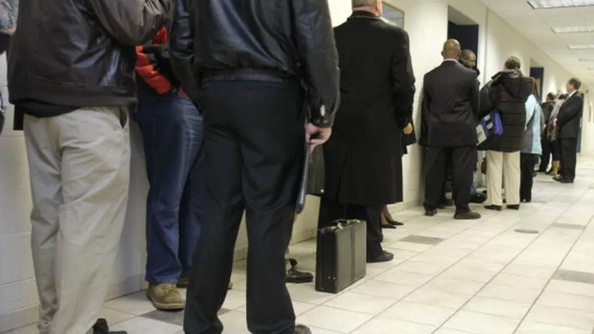People wait in line to attend a job fair.
