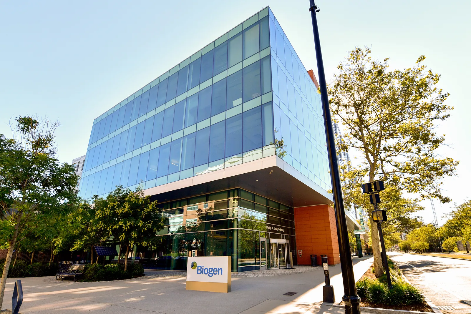 A glass building with a sign that reads,  "Biogen."