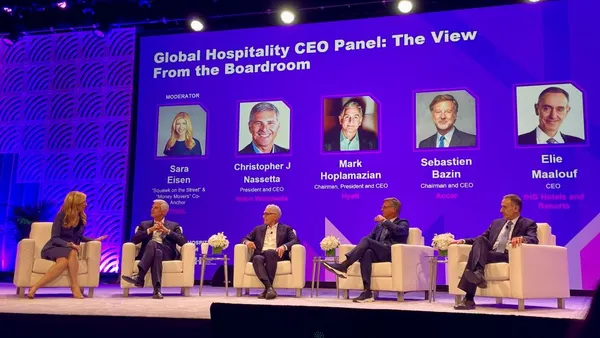 A group of executives sits on stage at the NYU International Hospitality Investment Forum in New York City.