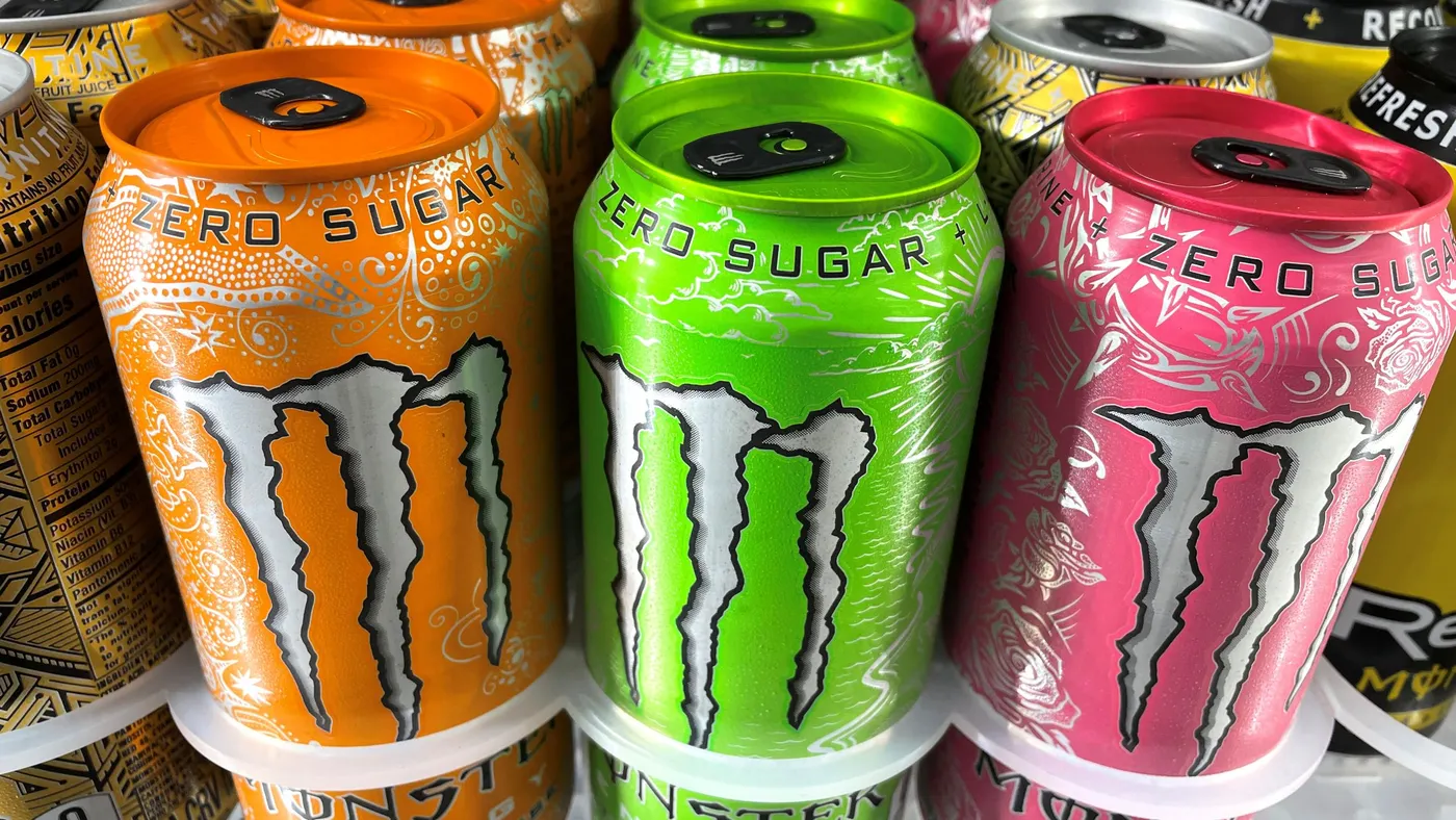 Cans of Monster are displayed on a store shelf.