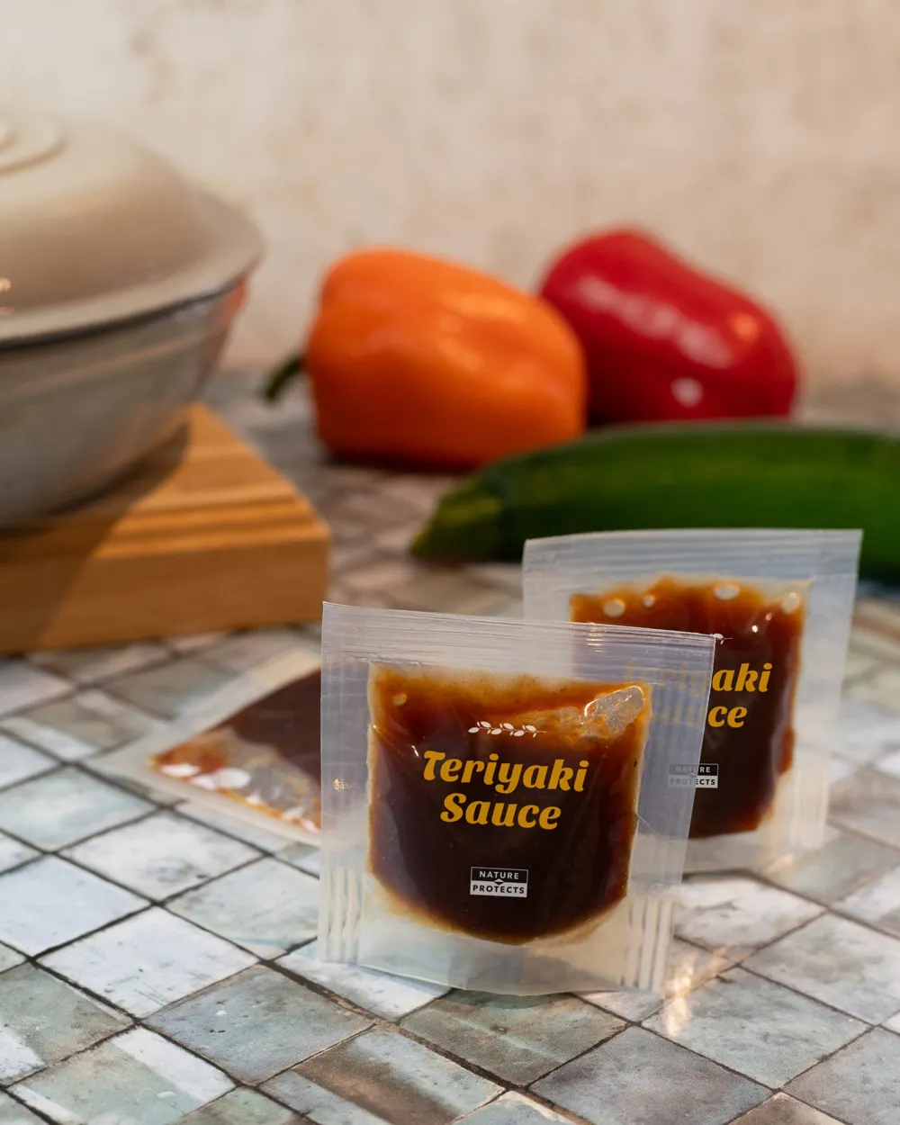 A small, clear plastic sachet containing a brown liquid, which is labeled teriyaki sauce.
