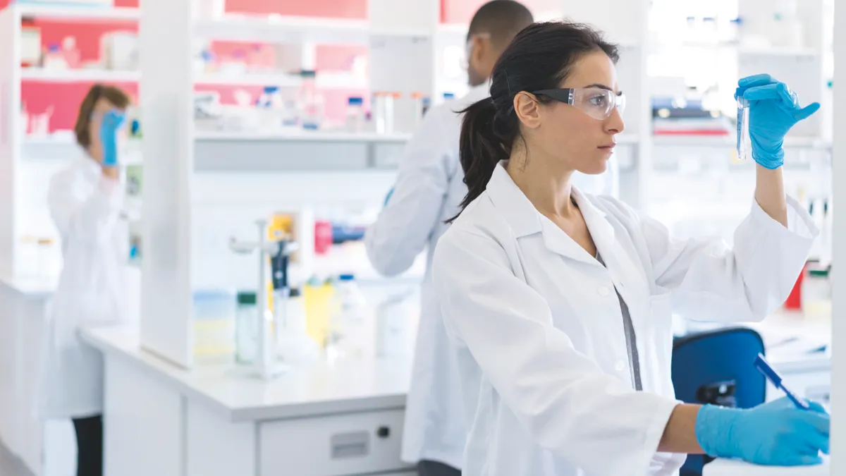 Female scientist looking at test tube.