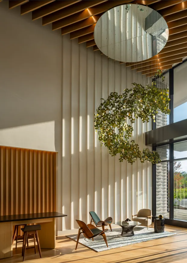 A communal space with a large mirror and sculpture hanging from the ceiling.