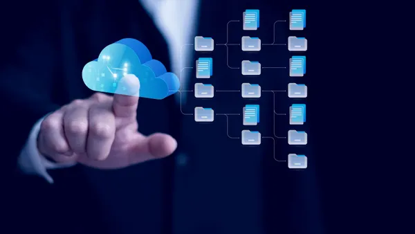 A picture of a hand touching a cloud icon on a screen.