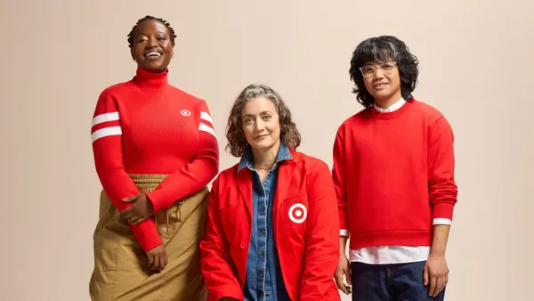 Three Target employee models wearing red branded shirts and sweaters