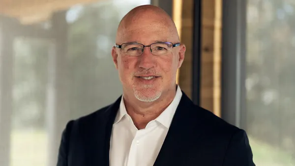 A photograph of a person wearing a black suit.