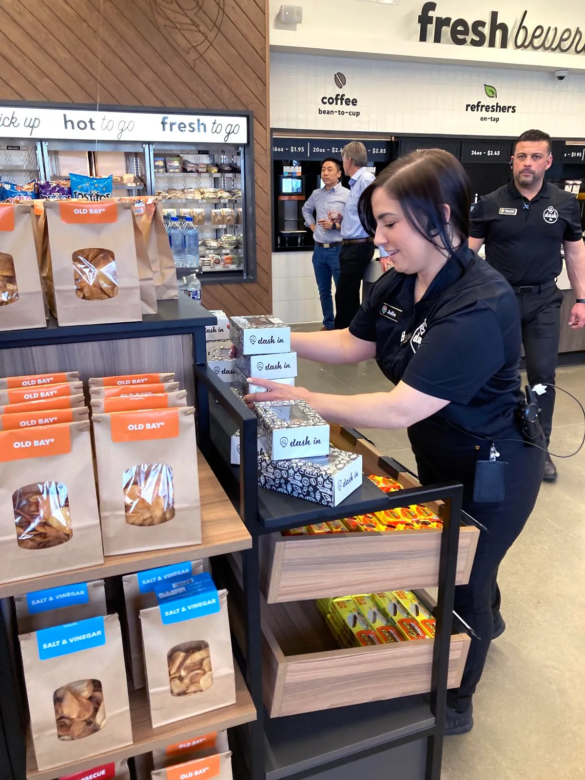 A photo of an employee stocking donuts at the new Dash In concept.