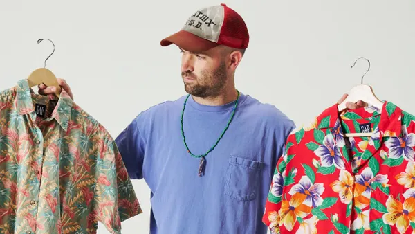 Sean Wotherspoon against a blank backdrop holding up two pieces from the new GapVintage collection.