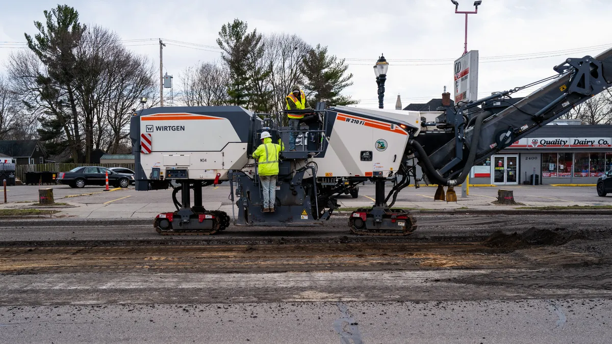 A work crew lays asphalt on a road