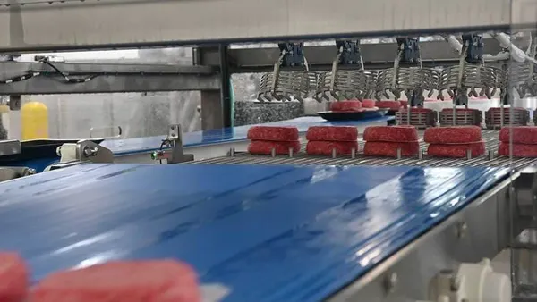 Beef patties are seen on a production line