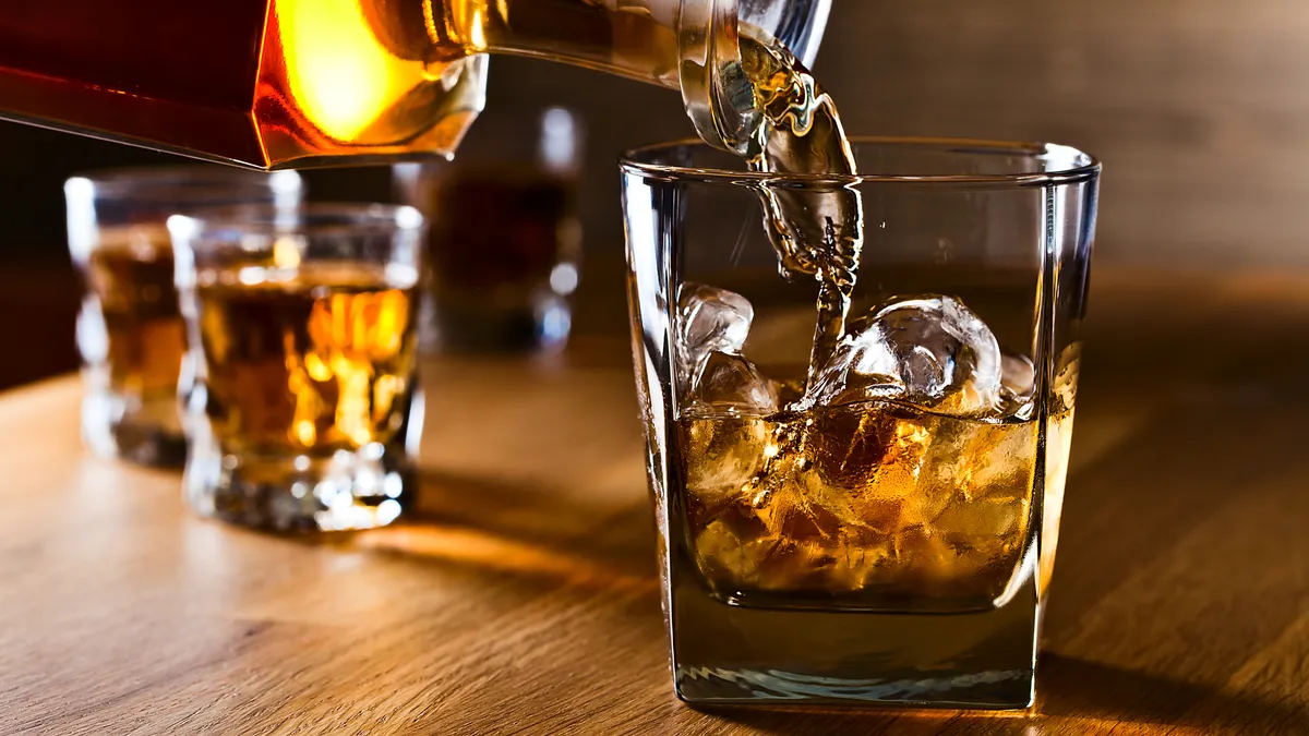 Whiskey and natural ice on old wooden table.