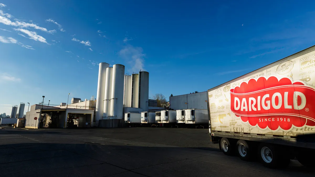 A truck bearing a Darigold logo leaves a manufacturing plant.