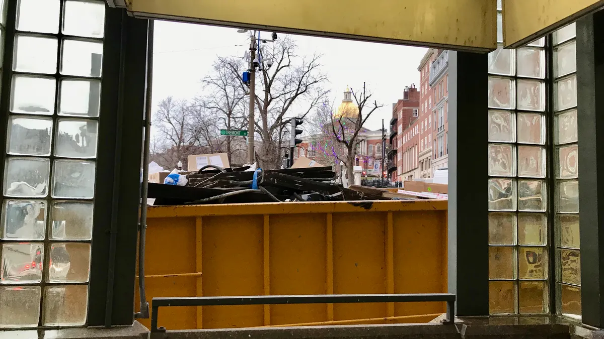 Massachusetts State House dome behind container of waste