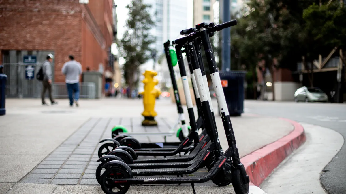 Shared scooters parked on a city sidewalk.