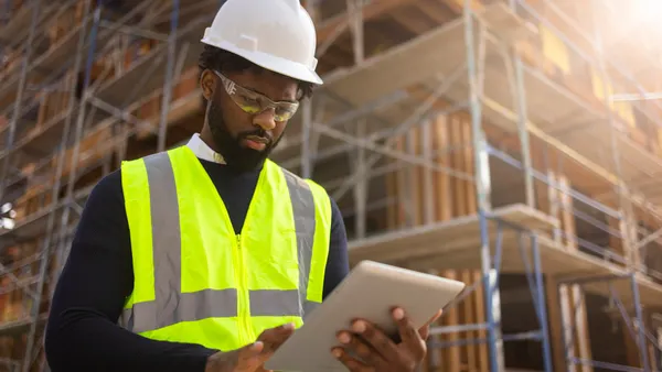 A young man is a project manager at a residential construction site.