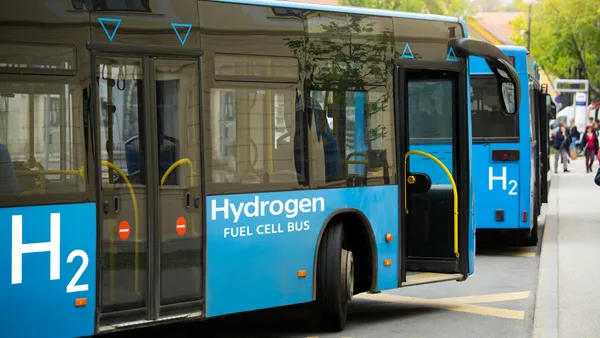 Hydrogen fuel cell buses at a bus stop.