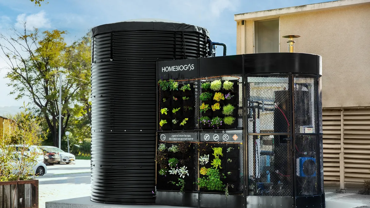 Commercial HomeBiogas digester (a black structure) outside in a parking lot