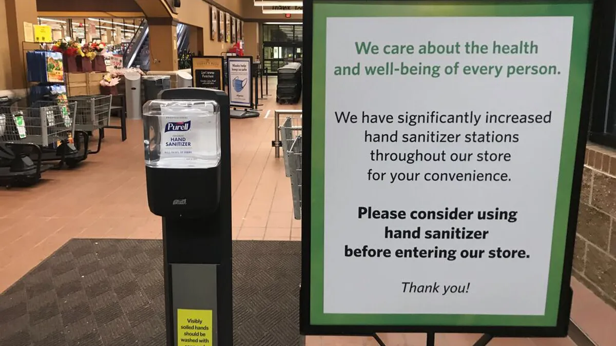 Hand sanitizer sign at front of Wegmans store