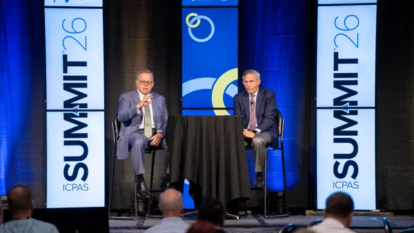 Two men speaking on stage at an accountants conference