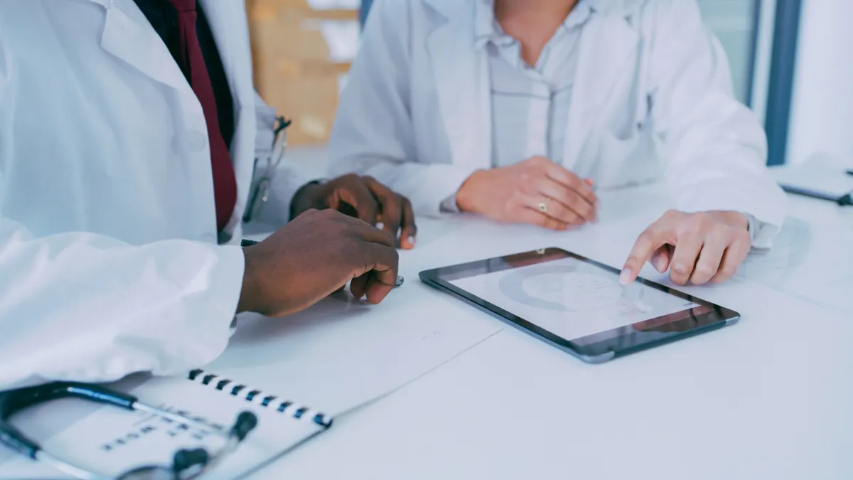 Shot of two doctors using a digital tablet during a discussion in a clinic.