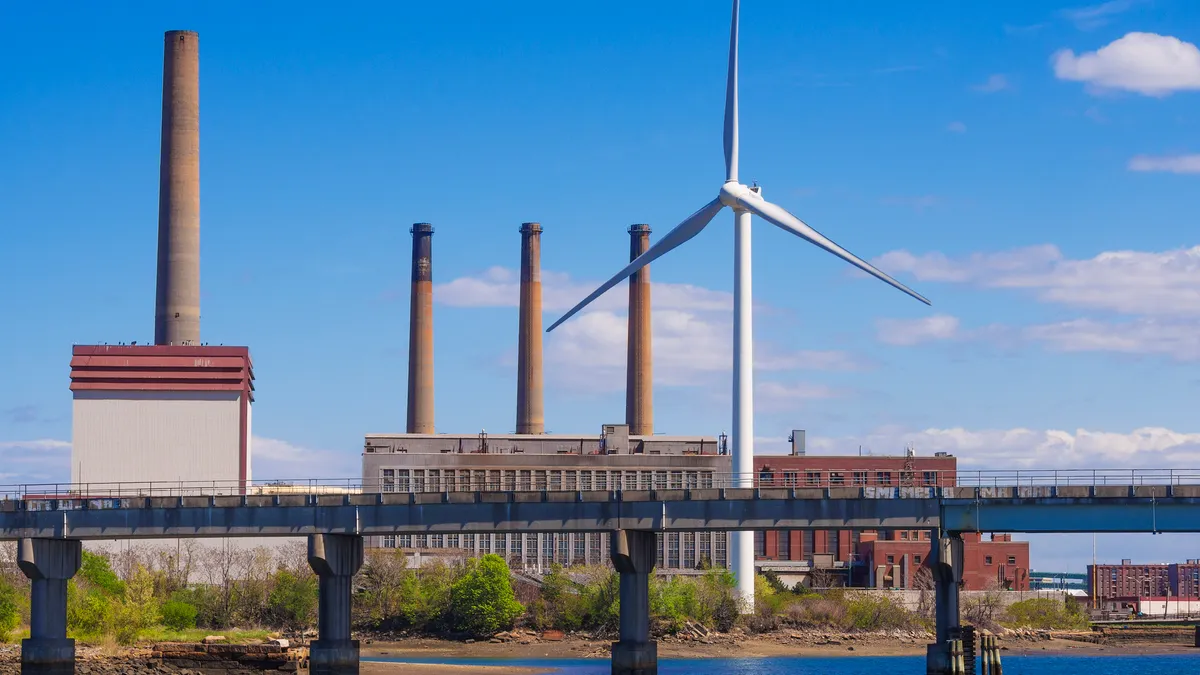 A wind turbine near a fossil fuel power plant in Massachusetts