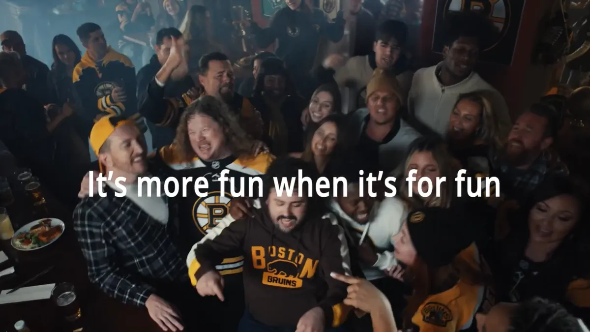 A crowd gathers at a bar in a DraftKings ad