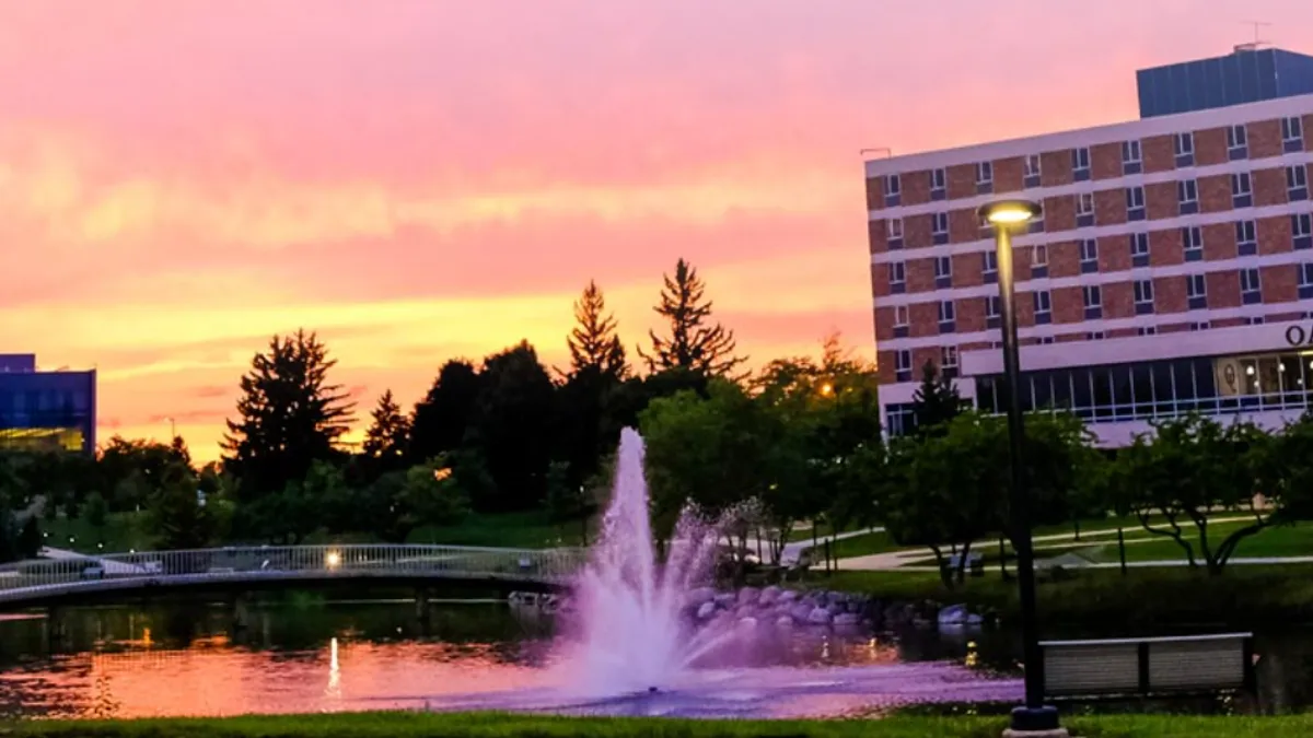 Oakland University campus at sunset with fountain in the foreground.