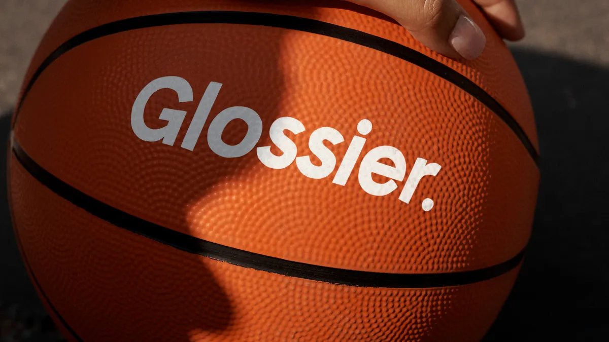 A basketball with "Glossier" printed across the front.