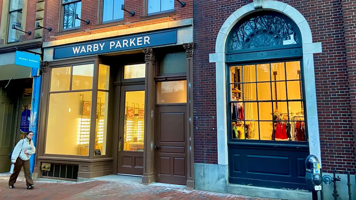 A person walks down a brick city sidewalk.