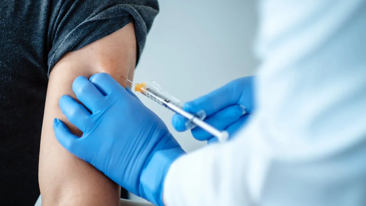 A volunteer in a clinical trial is dosed with BNT162, an experimental coronavirus vaccine developed by Pfizer and BioNTech