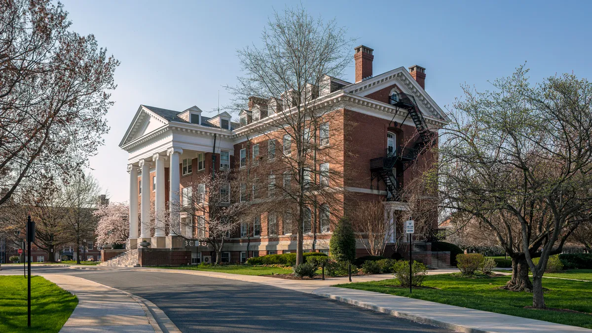 A brick academic building on a grassy mall.