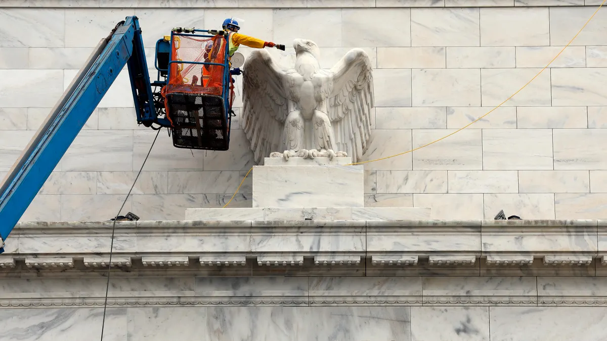 A construction worker paints an eagle