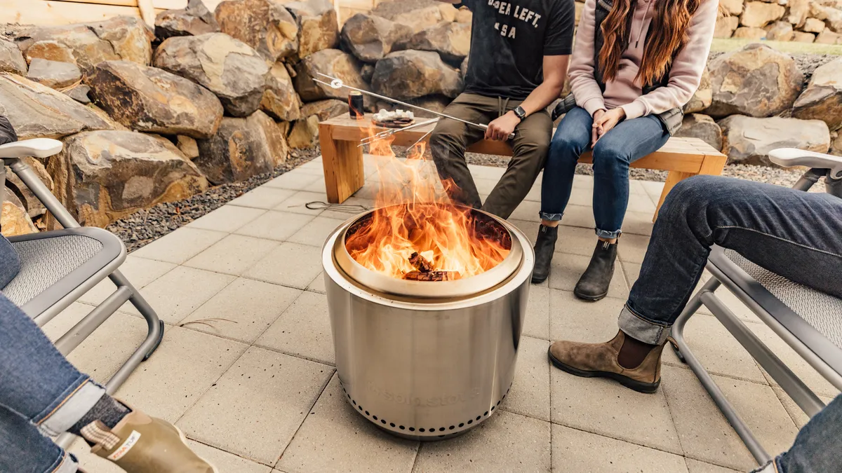 A group of people sitting around a Solo Stove fire pit.