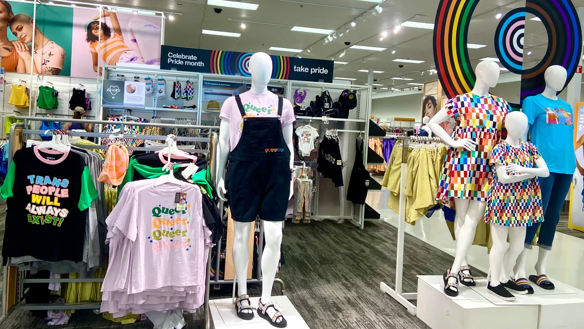 Mannequins and clothing racks in a store's display for Pride Month.