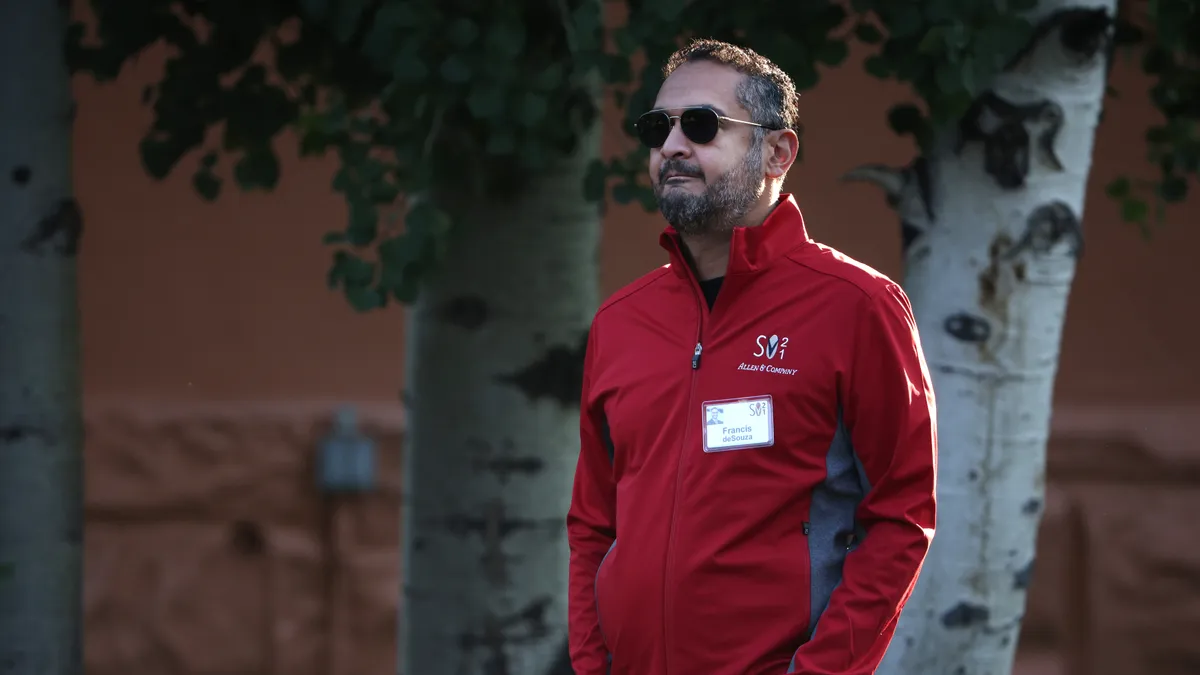 Illumina CEO Francis deSouza walking in a red jacket