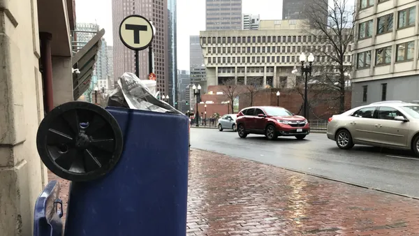 Upside down recycling cart in foreground, Boston City Hall in background