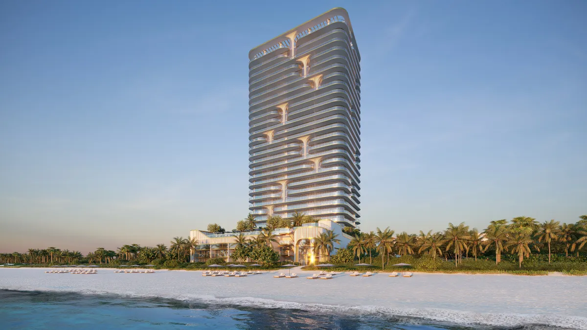 A tall white tower on a beachfront.