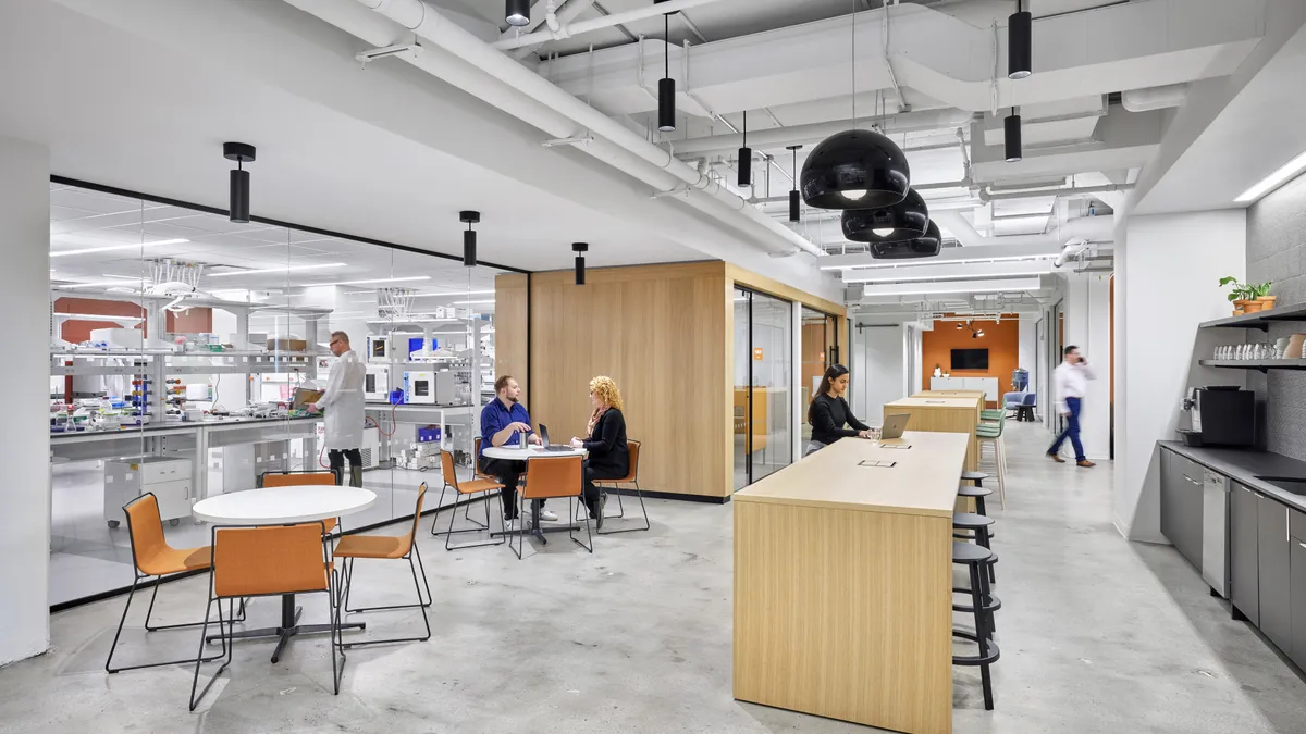 Workers walk through the halls of a modern laboratory