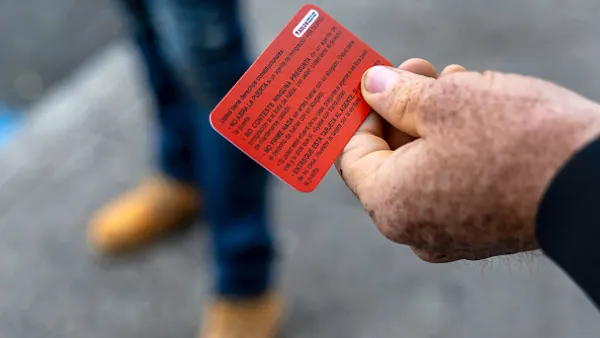 A hand holding a bright red card.