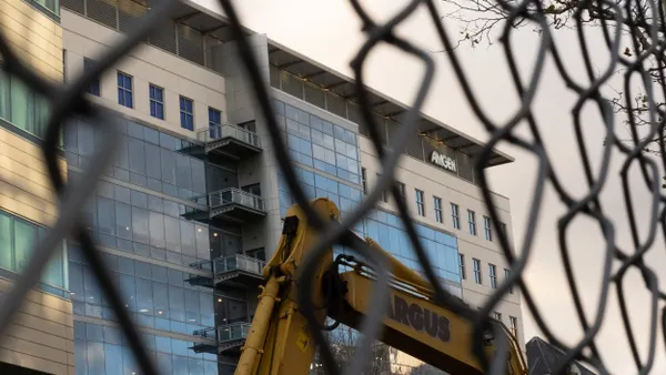A building is seen through a fence.