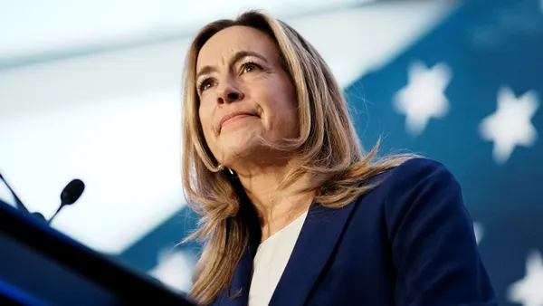 A woman stands at a podium.
