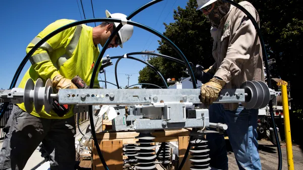 A utility crew works on heavy equipment.