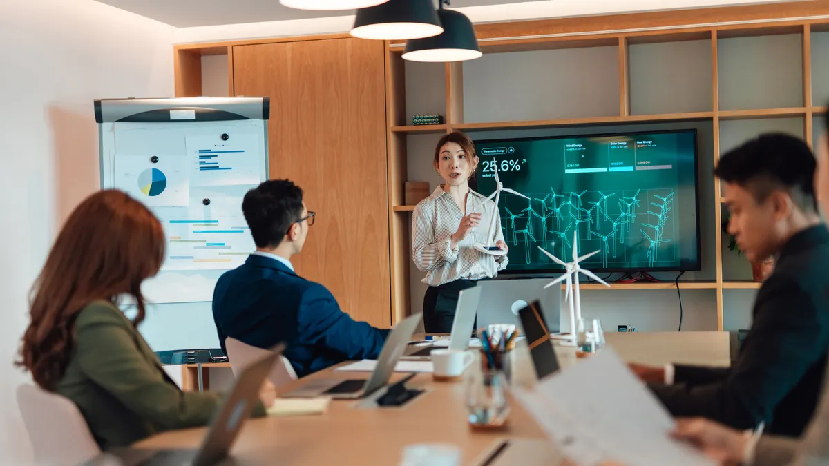 Asian businesswoman giving a presentation about renewable energy with graphs and data in boardroom
