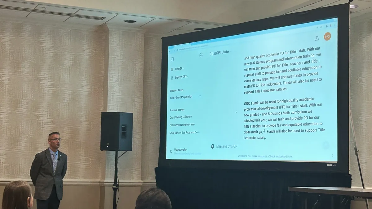 A school business official stands by a screen demonstrating how he uses ChatGPT to strategize grant application responses.