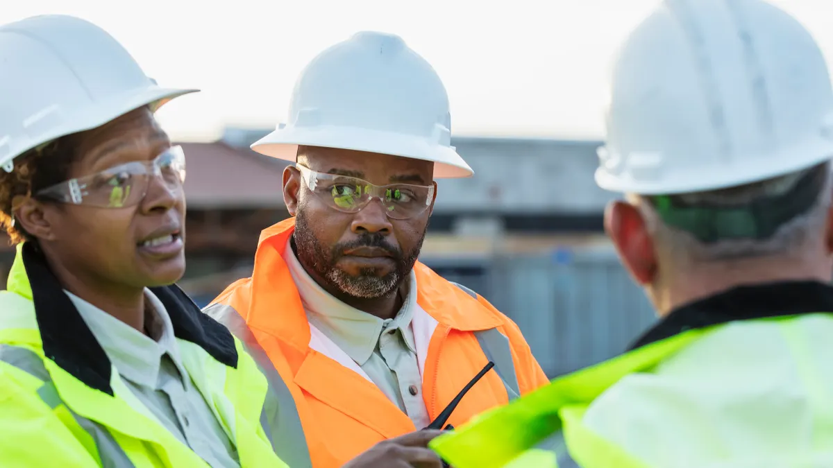 Diverse construction workers talk on a jobsite.