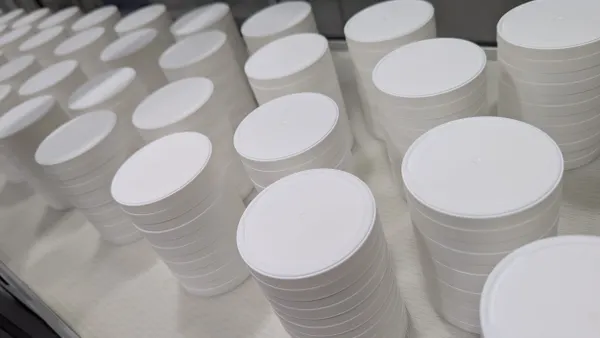 Rows of cylindrical plastic containers lined up.